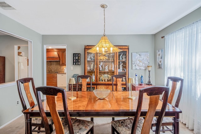 dining area with visible vents, a notable chandelier, light colored carpet, and baseboards