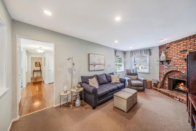living room featuring recessed lighting, carpet, a brick fireplace, and baseboards