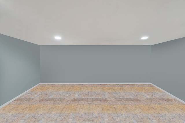 unfurnished room featuring baseboards, hardwood / wood-style floors, and recessed lighting