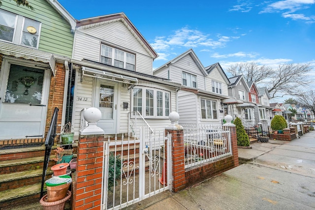 view of front of house featuring a gate, a residential view, and a fenced front yard