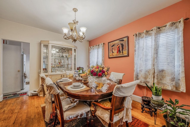 dining room with hardwood / wood-style flooring, baseboards, and a notable chandelier