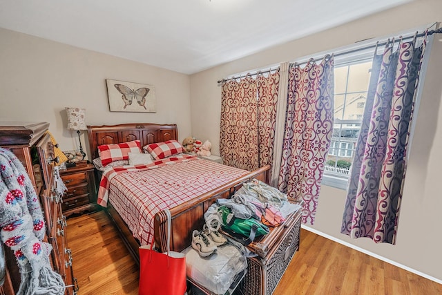 bedroom featuring wood finished floors and baseboards