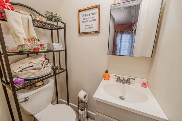 bathroom with baseboards, vanity, and toilet