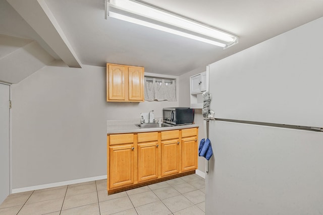 kitchen with light countertops, baseboards, light tile patterned flooring, and a sink