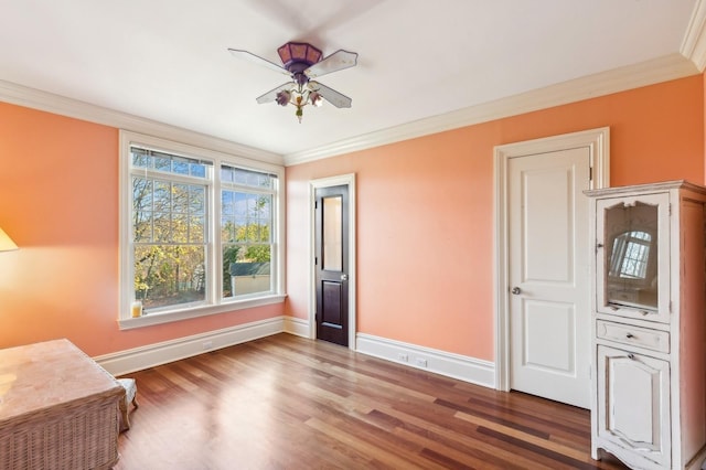 interior space featuring crown molding, baseboards, a ceiling fan, and wood finished floors