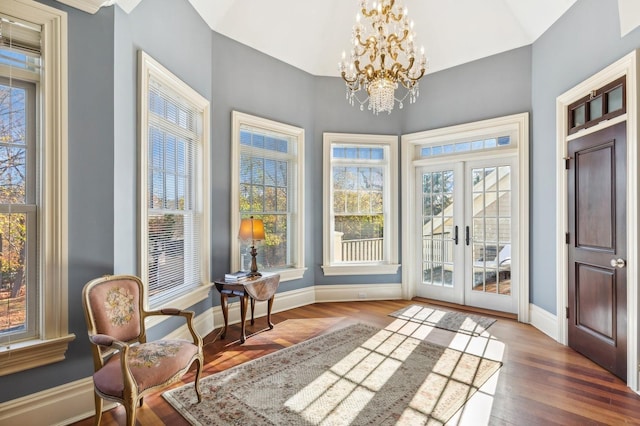 interior space with french doors, wood finished floors, baseboards, and a notable chandelier