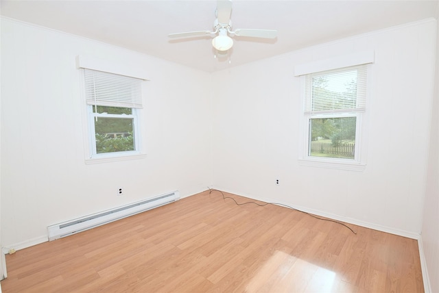 unfurnished room featuring baseboards, a baseboard heating unit, crown molding, ceiling fan, and light wood finished floors
