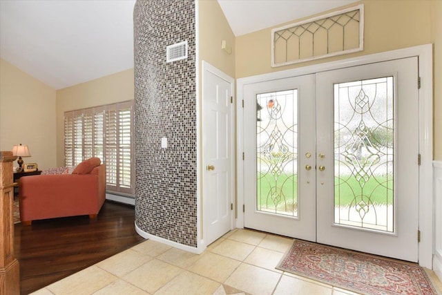 foyer with a baseboard radiator, french doors, and lofted ceiling