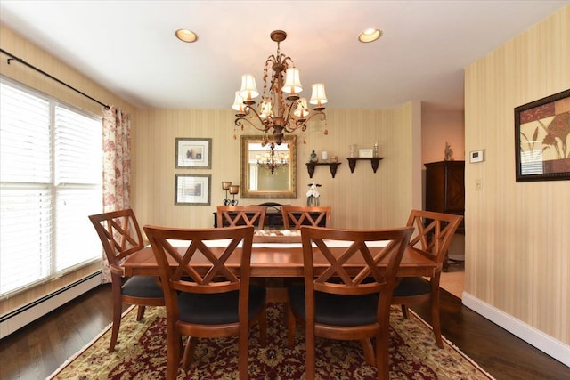 dining room with dark wood finished floors, a baseboard heating unit, wallpapered walls, a notable chandelier, and baseboards