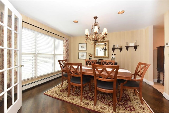 dining room featuring baseboards, an inviting chandelier, a baseboard heating unit, and wood finished floors