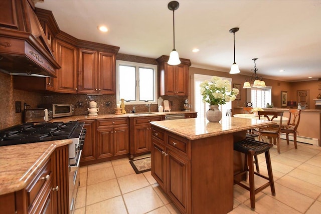 kitchen with a kitchen bar, stainless steel appliances, custom range hood, backsplash, and a baseboard heating unit
