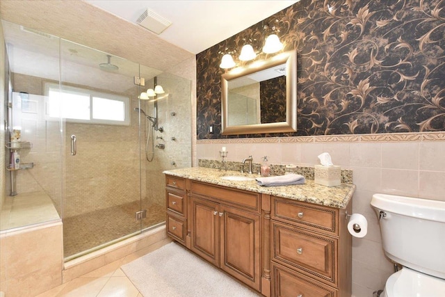bathroom with tile patterned flooring, toilet, a shower stall, visible vents, and tile walls