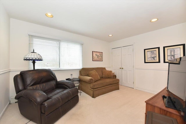 living area with a baseboard radiator, recessed lighting, and light colored carpet