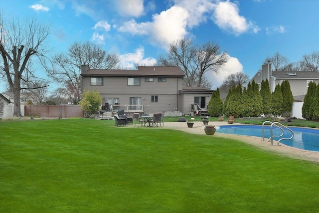 rear view of house with a yard, entry steps, fence, a patio, and a fenced in pool