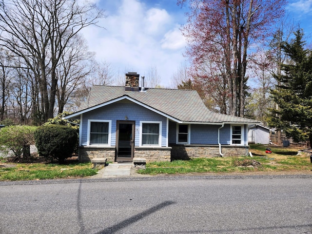 view of front of home with a chimney and stone siding