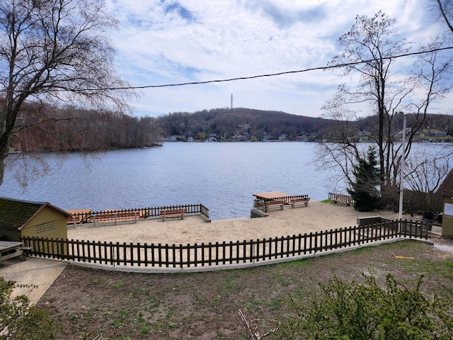 dock area with a water view and fence