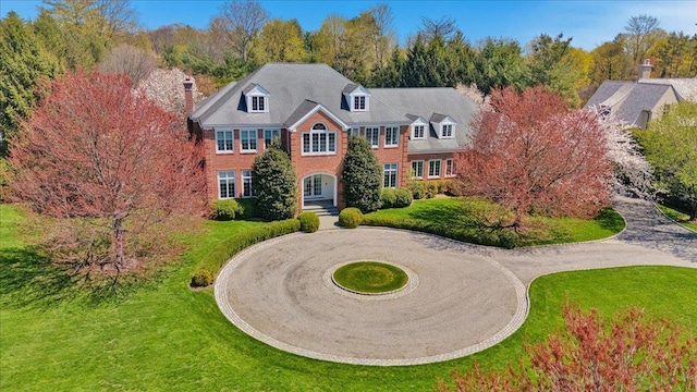 30 Morris Ln, Scarsdale, NY 10583 - colonial-style house with a chimney, a front lawn, brick siding, and curved driveway