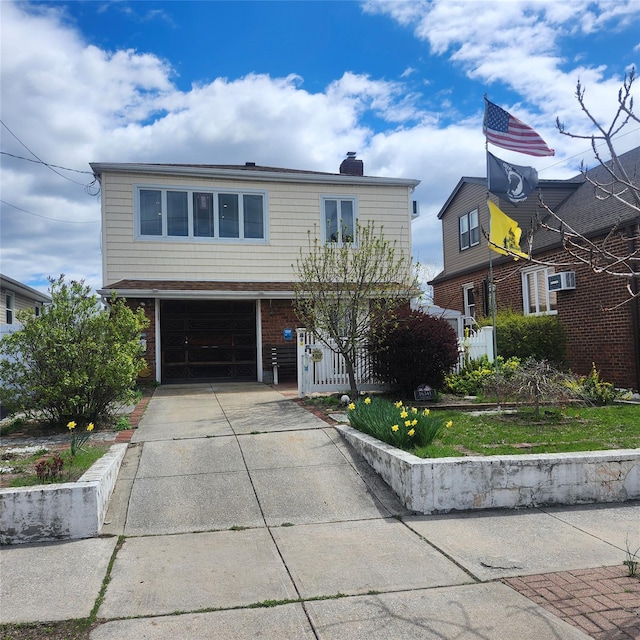 traditional home with an attached garage, a chimney, driveway, and brick siding