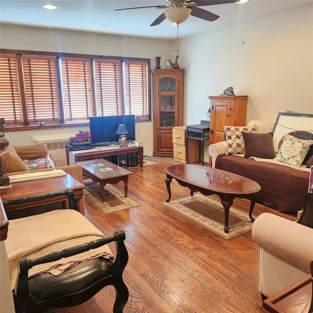 living room featuring light wood finished floors, radiator, ceiling fan, and recessed lighting