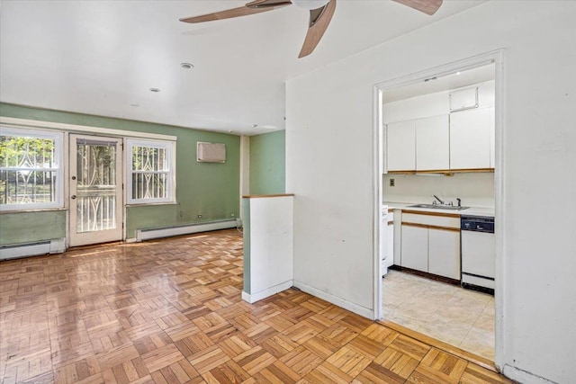 interior space with a ceiling fan, light countertops, white cabinets, a baseboard radiator, and dishwasher