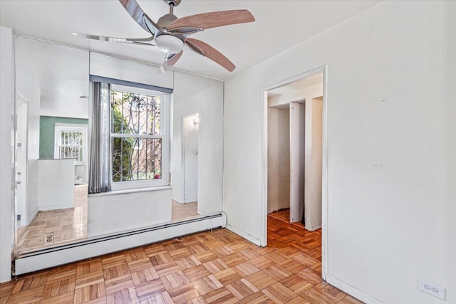 spare room featuring baseboards, ceiling fan, and baseboard heating