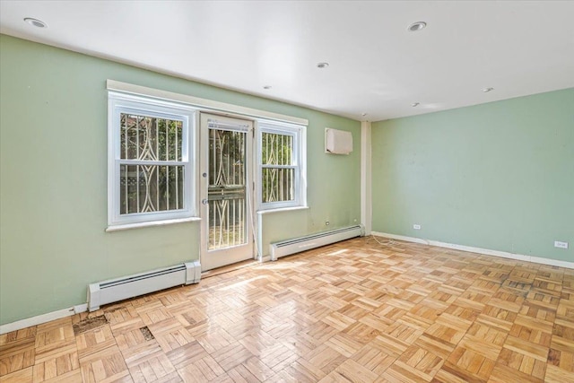 spare room featuring baseboards, a baseboard heating unit, and a wall unit AC