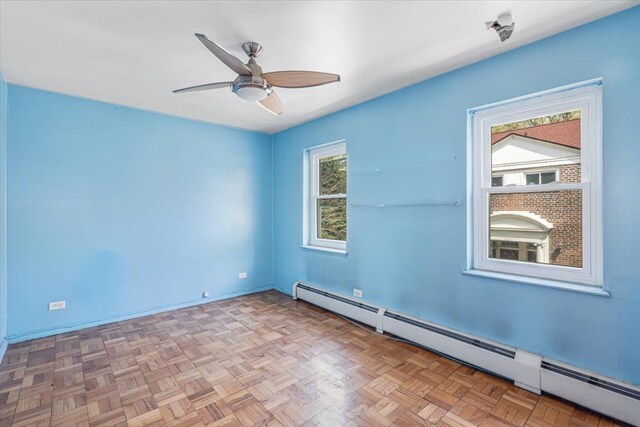 unfurnished room with baseboards, ceiling fan, and baseboard heating