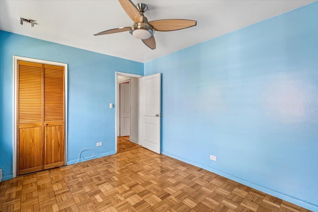 unfurnished bedroom with baseboards, a ceiling fan, and a closet