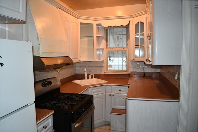 139-15 89th Ave, Briarwood, NY 11435 - kitchen with exhaust hood, stainless steel gas stove, a sink, freestanding refrigerator, and glass insert cabinets