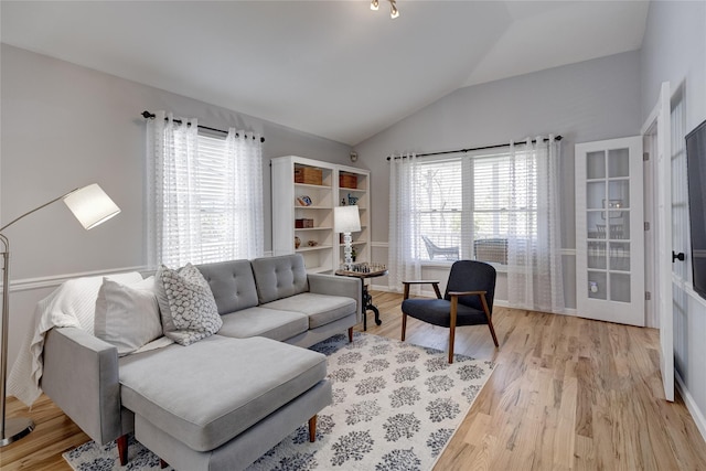 living area with lofted ceiling and light wood-style flooring