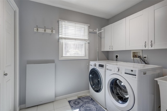 washroom featuring baseboards, cabinet space, washer and clothes dryer, and light tile patterned flooring