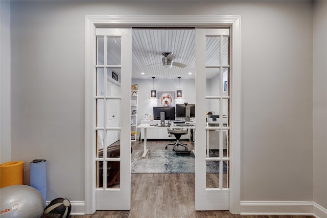 office featuring wood finished floors, ceiling fan, and french doors