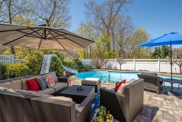 view of pool with a fenced backyard, a patio, a fenced in pool, an outdoor hangout area, and a water slide