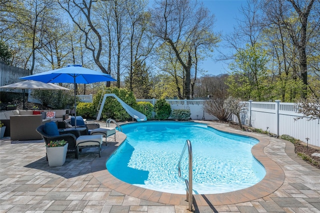 view of pool featuring a fenced in pool, a fenced backyard, a water slide, outdoor lounge area, and a patio