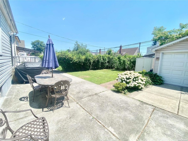 4947 166th St, Fresh Meadows, NY 11365 - view of patio featuring an outdoor structure, outdoor dining space, and a garage