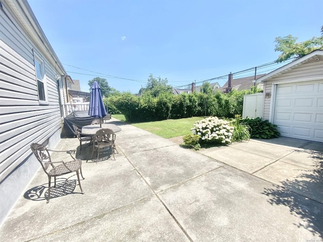 4947 166th St, Fresh Meadows, NY 11365 - view of patio / terrace with grilling area, concrete driveway, and a garage