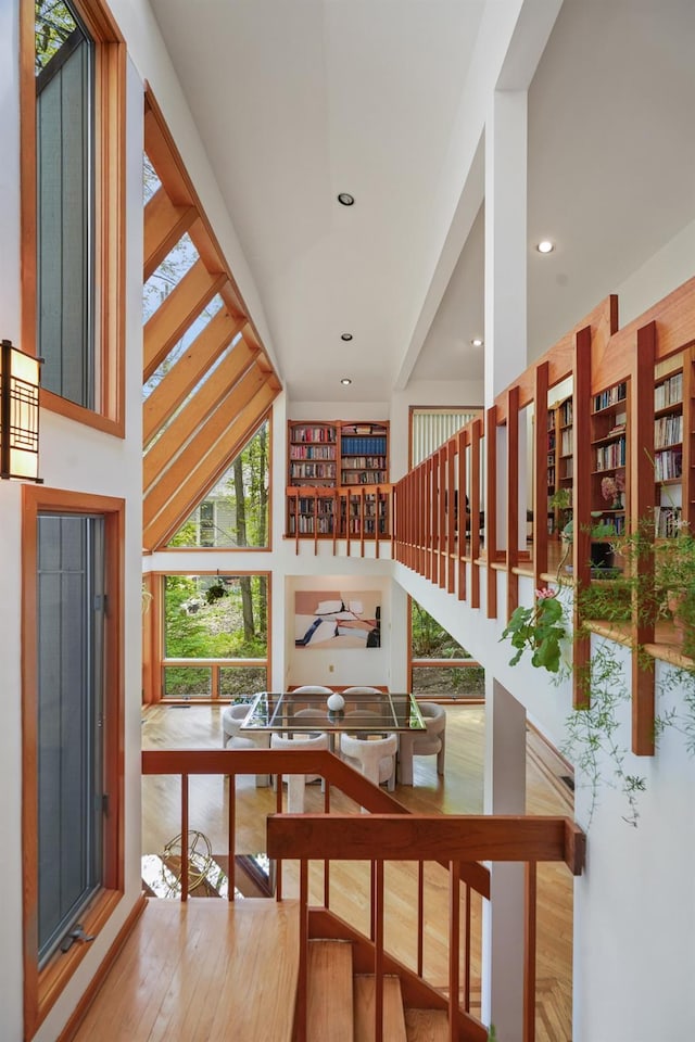 interior space with recessed lighting, a high ceiling, and wood finished floors