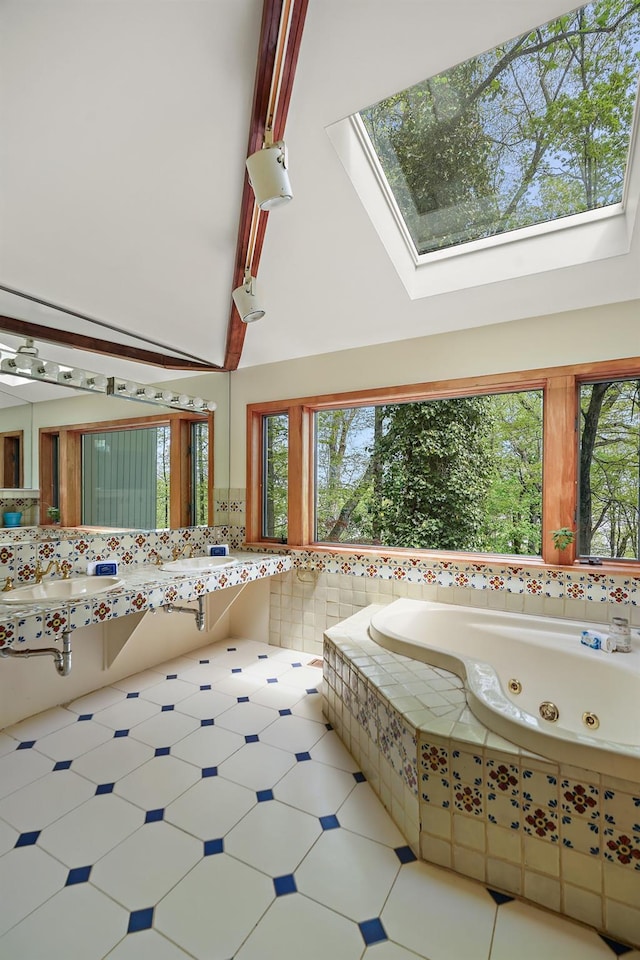 full bathroom with a skylight, a jetted tub, and a sink
