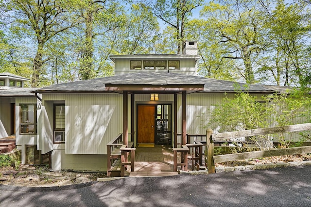 prairie-style house featuring a shingled roof and a chimney