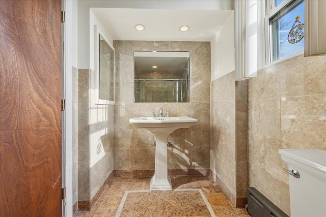 full bathroom with tile walls and a shower with door