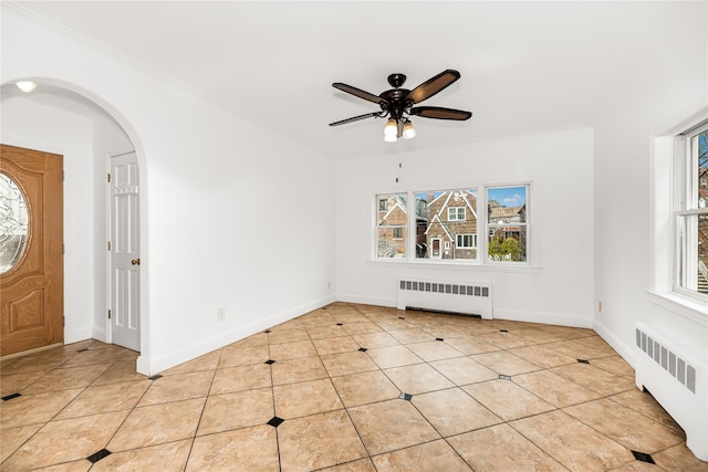 foyer entrance with radiator, light tile patterned flooring, and plenty of natural light