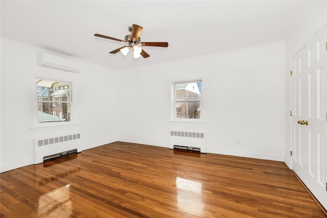 unfurnished room featuring radiator heating unit, ceiling fan, wood finished floors, and a wall unit AC