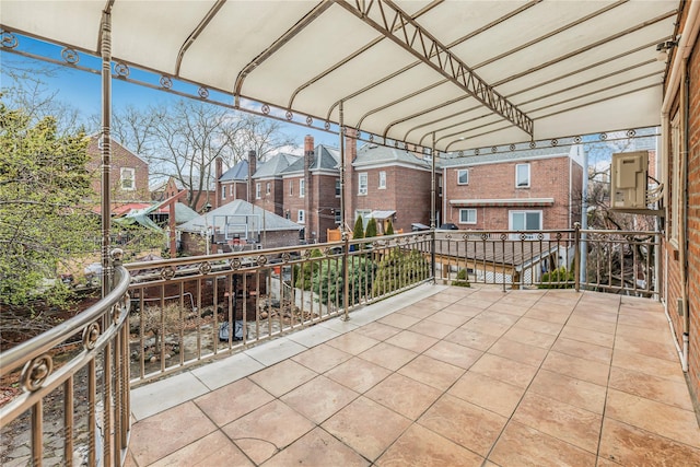exterior space with a residential view, a balcony, and a detached carport