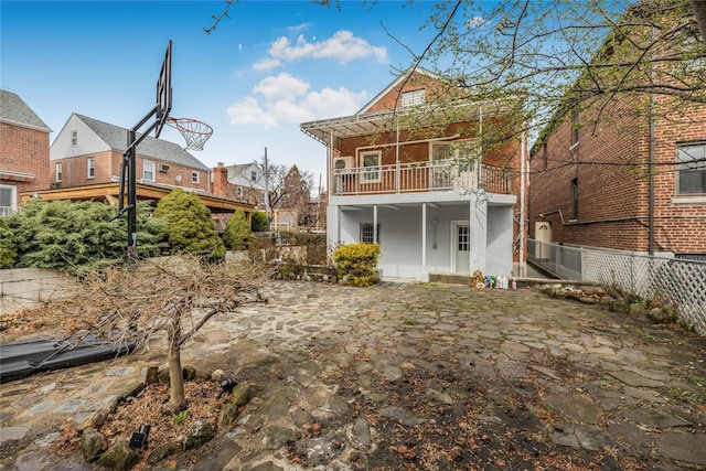 back of house with fence and a balcony