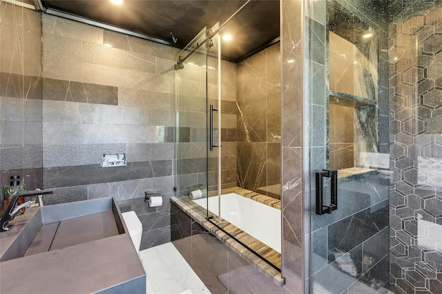bathroom with tile walls, a sink, and tiled shower / bath combo