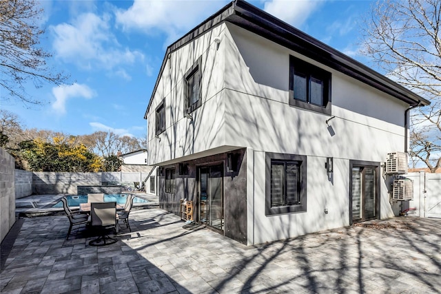 back of house with stucco siding, a patio area, a fenced in pool, and a fenced backyard