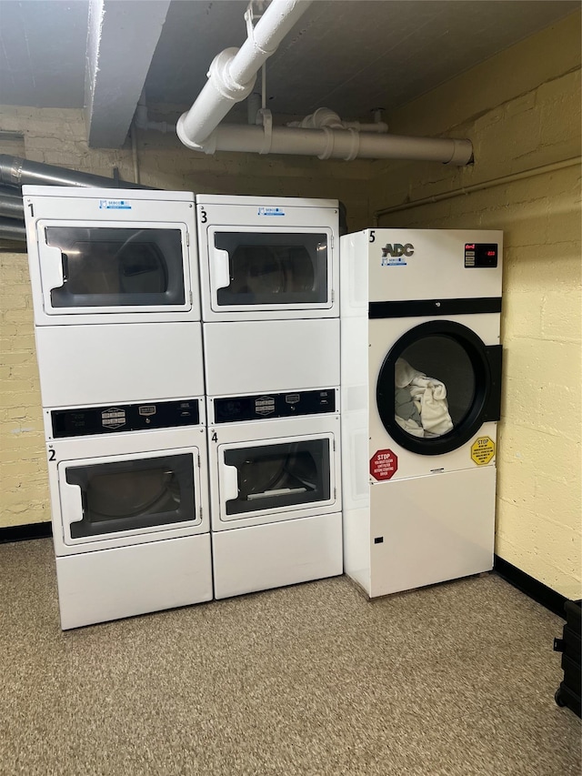 shared laundry area with stacked washing maching and dryer, washer and clothes dryer, and baseboards