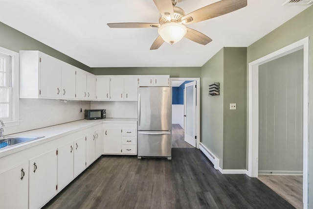 kitchen featuring dark wood-style floors, a sink, freestanding refrigerator, baseboard heating, and black microwave