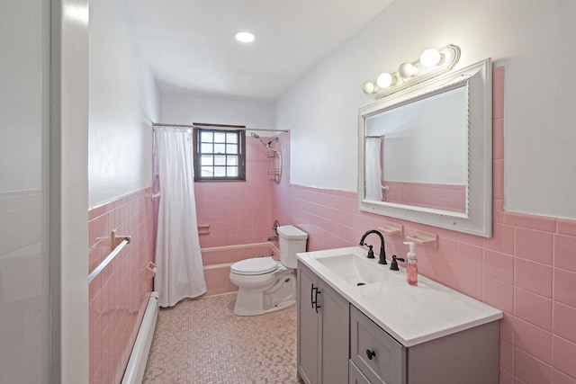 bathroom with a baseboard heating unit, wainscoting, vanity, and tile walls