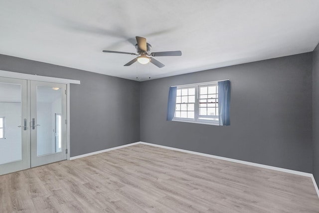 unfurnished room featuring baseboards, french doors, wood finished floors, and ceiling fan